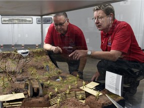 Royal Canadian Legion Regina Branch 001 museum board members Mack Howat, left, and Glenn Bird look over an interpretation of a scene from the Battle of Vimy Ridge.