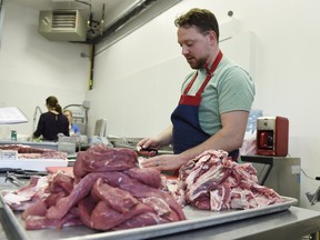 Greg Reid, the owner and butcher at Reid's Artisanal Butchery in Regina, prepares lamb for market.