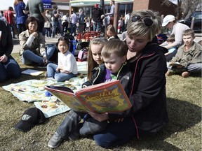 Ashley Quark read a book with her daughter, Anna Bruce-Quark, and son Ian Bruce-Quark at the Drop Everything and Read rally held in Regina on Friday.