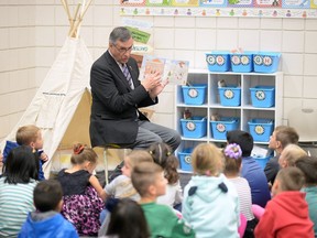 Saskatchewan Party MLA Don Morgan read a story to Sienna Borland's grade 1 and 2 class at W.F. Ready School in Regina in September 2016 while promoting literacy. Today he's on the defensive over cuts to libraries in the provincial budget.