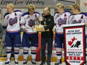 Regina Pat Canadians players, left to right, Tyler Lees, Alexander Kannok Leipert, Matthew Chekay and Lukas Sillinger receive the championship trophy Sunday after winning the Telus Cup west regional qualifier in Steinbach, Man.