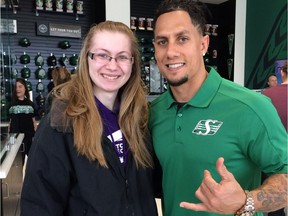 The Saskatchewan Roughriders' Chad Owens poses with Gabrielle Kyrylchuk during the grand opening of the team's new store at Mosaic Stadium on Saturday.