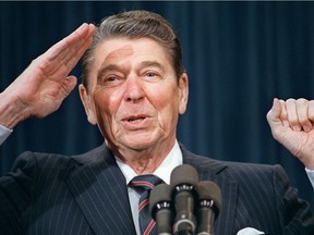 Then-U.S. president Ronald Reagan salutes as he tells a joke during his address to the leadership of the American Legion Feb. 10, 1987 at the White House in Washington, D.C.