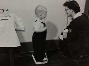 A public health worker from Saskatchewan's pioneering Swift Current Health Region No. 1 weighs a child in 1953.