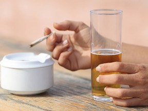 Hands holding a cigarette smoking and drinking alcohol