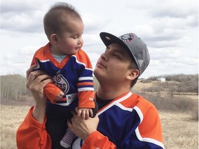 Andrew Pasap, 19, holds his nine-month-old daughter Anaya.