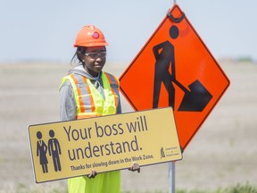 Flag person Diana Lumbala holds a sign during a press conference about highway construction and safety.