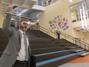 Rodd Hoffart, superintendent of facilities of Regina Catholic Schools, stands before the staircase risers at the new Sacred Heart School. The glass windows of the library are top right.