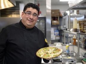 Sergio Reyna, culinary manager of Roots Kitchen & Bar, holds a plate of fish tacos.