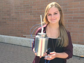 Kristi Hayko poses with her homemade calorimeter. She is one of four finalists in the Canada-Wide Science Fair from Regina. Her calorimeter measures the amount of energy created by solid waste when it is burned, energy that could then be used for power.