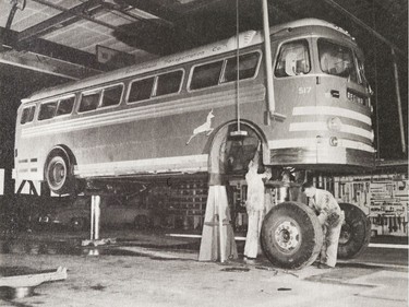A photo of the Provincial Archives of Saskatchewan Photograph No. 55-609-03, that says "Mechanics work on a Saskatchewan Transportation bus - overhaul and repair while the bus is raised on a hoist - at the company garage" taken Jan. 1956.