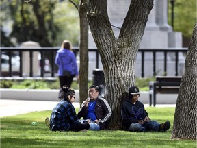 A small group pf people visit while having a cigarette in Victoria Park. With the changes to the smoking bylaw, Victoria Park will no longer be a place to smoke.