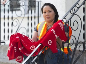 Oochoo, president of White Pony Lodge, holds a red dress outside the group's office in honour of MMIWG