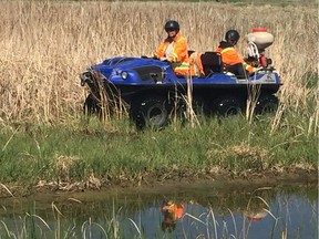 Two City of Regina employees treat a water body with Vectobac, an organic product used to control mosquito populations.