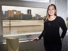 Carley Winter at her south facing window in her condo looking out towards the former CP railyard.