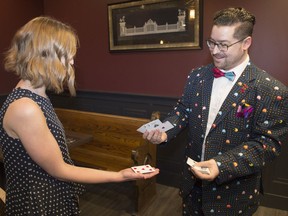 Magician Keegan Duck, right, performs a card trick for Leader-Post reporter Ashley Robinson prior to the announcement of ReginaCadabra, a magic festival coming to the city.