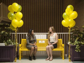 Paramedic students Danniela Morgan, left, and Carlee Smith, right, pose on a yellow bench in a hallway at Saskatchewan Polytechnic. Called the Yellow Friendship Bench, the idea is to encourage conversations about mental health among students and staff.