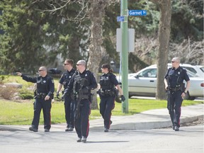 Regina Police Service members cross the intersection of McCallum Street and Garnet Street.