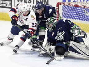 Sam Steel of the Regina Pats fights off Turner Ottenbreit of the Seattle Thunderbirds on a wraparound try against goalie Carl Stankowski in Game 1 of the WHL final on Friday night.