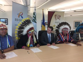 City of Regina Mayor Michael Fougere (centre) and FSIN Chief Bobby Cameron (second from left) smile at each other after signing a memorandum of understanding on the elimination of racism Tuesday at the First Nations University of Canada. Chief Roger Redman (second from right), Chief Michael Starr (far left) and Chief Alvin Francis (far right) also signed the MOU.