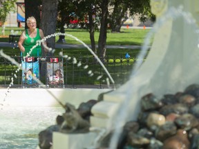 Lorraine Gergely watches water stream from a restored fountain at Confederation Park near Mosaic Stadium.