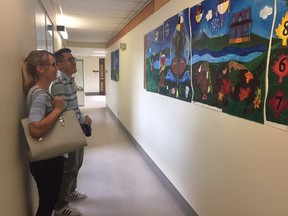 Members of the City of Regina's Confederation Park Public Art Project team Yi Che (right), art preparator and Élise Beaudry-Ferland (left), community consultant, look at paintings done by 62 high school students. The paintings tell the complex history of Confederation and will be permanently displayed at Confederation Park.