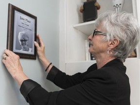 June Draude hangs a plaque at "June House" — one of two new homes operated by Oxford House Society of Regina. The Hillsdale neighbourhood house will be home to a community of people recovering from drug and alcohol addiction.