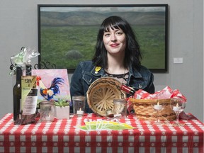 Jess Richter, program coordinator of the Art Gallery of Regina, poses in front of paintings by Mike Keepness.