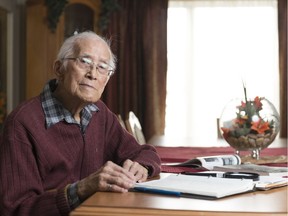 Reginald Bing-Wo sits with his notes and a book on the Gardiner Dam at his home at College Park Retirement Residence. Bing-Wo was one of the engineers who worked on the Gardiner Dam.