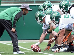 Mike Scheper (left) has gone from offensive line coach to defensive assistant to energy coach and Murray's Monster with the Riders.
