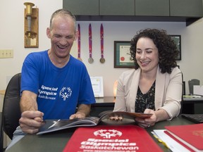 Robbie Bomber, a special Olympian athlete, and Faye Matt, CEO of Special Olympics Saskatchewan, look over a book that includes the bid to host the 2020 Special Olympics Canada Winter Games in Regina.