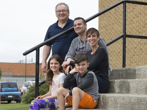 Keith Beaurivage, top, Claude and Ginger Beaurivage, middle, and Lily and Regan Beaurivage, bottom, sit on the steps of St. Andrew School.