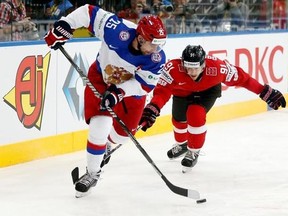 FILE - This is a Friday, May 9, 2014 file photo of Russia&#039;s Danis Zaripov, left, as he is challenged by Switzerland&#039;s Robin Grossmann during the Group B preliminary round match between Switzerland and Russia at the Ice Hockey World Championship in Minsk, Belarus. Danis Zaripov, who played for Russia at the 2010 Olympics, is among three Kontinental Hockey League players banned for doping. The league said Tuesday July 25, 2017 that Zaripov tested positive during the 2016-17 season for unnamed subs