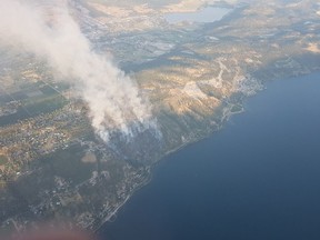 Smoke rises from a wildfire north of McKinley Landing on the east side of Okanagan Lake on Sunday, July 16, 2017. Eight homes were destroyed by the 55-hectare fire.