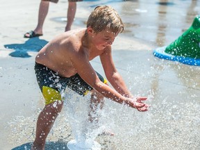 Drew Delnea beats the summer heat by cooling off in the spray park at the Sandra Schmirler Leisure Centre in Regina, Saskatchewan on July 29, 2017.