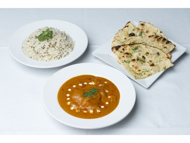 A meal of butter chicken, jeera rice, and naan bread.