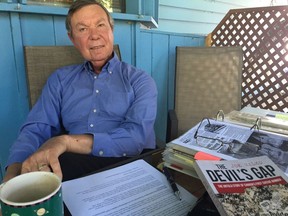 Regina resident Joe Ralko with his new book The Devil's Gap and his binder of research material that he relied upon in writing about a suicide bombing in Kenora, Ont. in 1973.