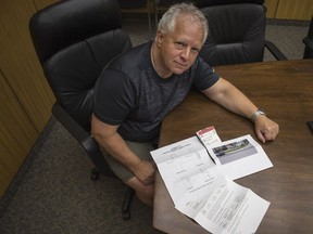 Saskatoon's Doug Paik sits with his parking ticket and documentation from the City of Regina.