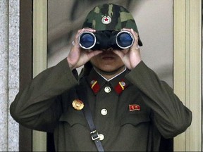 In this Tuesday, April 23, 2013, file photo, a North Korean soldier looks at the southern side through a pair of binoculars at the border village of Panmunjom, which has separated the two Koreas since the Korean War, in Paju, north of Seoul, South Korea. Threatening to fire a volley of missiles toward a major U.S. military hub _ and the home to 160,000 American civilians _ may seem like a pretty bad move for a country that is seriously outgunned and has an awful lot to lose. But pushing the envelope, or just threatening to do so, is what North Korea does best. (AP Photo/Lee Jin-man, File)