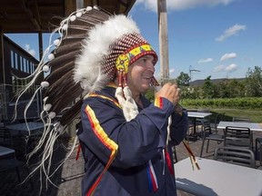 Perry Bellegarde, National Chief of the Assembly of First Nations, adjusts his headdress at a meeting of Atlantic MPs and First Nations chiefs in Wolfville, N.S. on Thursday, Aug. 10, 2017. Assembly of First Nations National Chief Perry Bellegarde says it will be important to work with Indigenous Peoples south of the border to garner support as Canada looks for a chapter of NAFTA focused on Aboriginal rights. THE CANADIAN PRESS/Andrew Vaughan