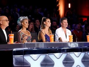 In this Tuesday, Aug. 22, 2017 photo provided by NBC, judges Howie Mandel, Mel B, Heidi Klum and Simon Cowell participate in a live broadcast of &ampquot;America&#039;s Got Talent&ampquot; in Los Angeles. Mel B threw a cup of water on Cowell and walked off the stage after Cowell made a joke about her wedding night during the show. (Trae Patton/NBC via AP)