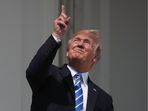 U.S. President Donald Trump glances up at the Aug. 21 solar eclipse from the White House in Washington, D.C.