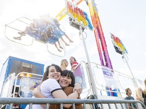 Kelsi Biletski, bottom left, and Ashley Melenchuk, bottom center left, hug before going on the Mach 3 at the Queen City Ex.