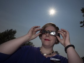Jessica Bickford, marketing co-ordinator for the Saskatchewan Science Centre, wears a pair of approved glasses to view the upcoming solar eclipse.
