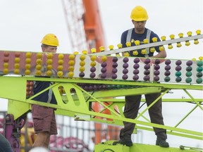 Pieter Espin, right, and Christoff May, left, both from South Africa, set-up the Cliffhanger ride for the Queen City Ex at Evraz Place.