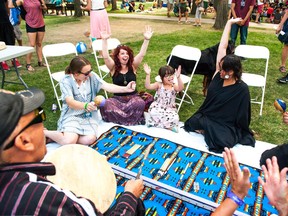 Marley Reakes (centre) won a game of traditional indigenous hand games during Regina Folk Festival on Sunday.