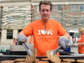 Mayor Michael Fougere flips burgers during I Love Regina Day in City Square Plaza in 2013.