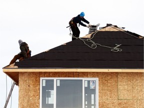 Crews work on shingling a house in east Regina in 2013.