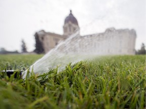 A water sprinkler waters the lawn out front the Legislative Building in Regina.