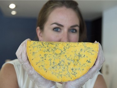 Aleana Young holds up half a wheel of Shropshire cheese at her new store, Takeaway Gourmet.
